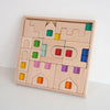 A wooden building block set featuring colorful acrylic blocks shaped like houses and structures.