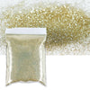 A bag of holographic fine glitter powder scattered on a white surface.