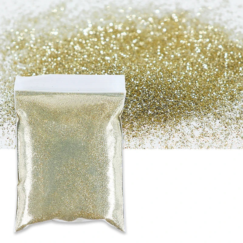 A bag of holographic fine glitter powder scattered on a white surface.