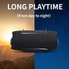 A black portable Bluetooth speaker is shown against a sunset and night sky background.