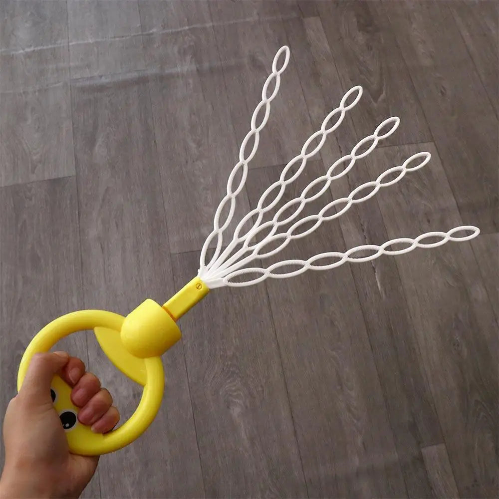 A hand holds a yellow bubble wand with a smiling face, from which white strings extend to form many bubbles.