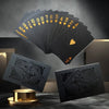 A stack of black and gold playing cards is shown alongside a single card on a dark surface.