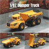 A yellow 1/87 scale dumper truck diecast model is shown in a studio setting.