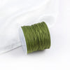A roll of olive green cotton nylon macrame cord for jewelry making and crafts.