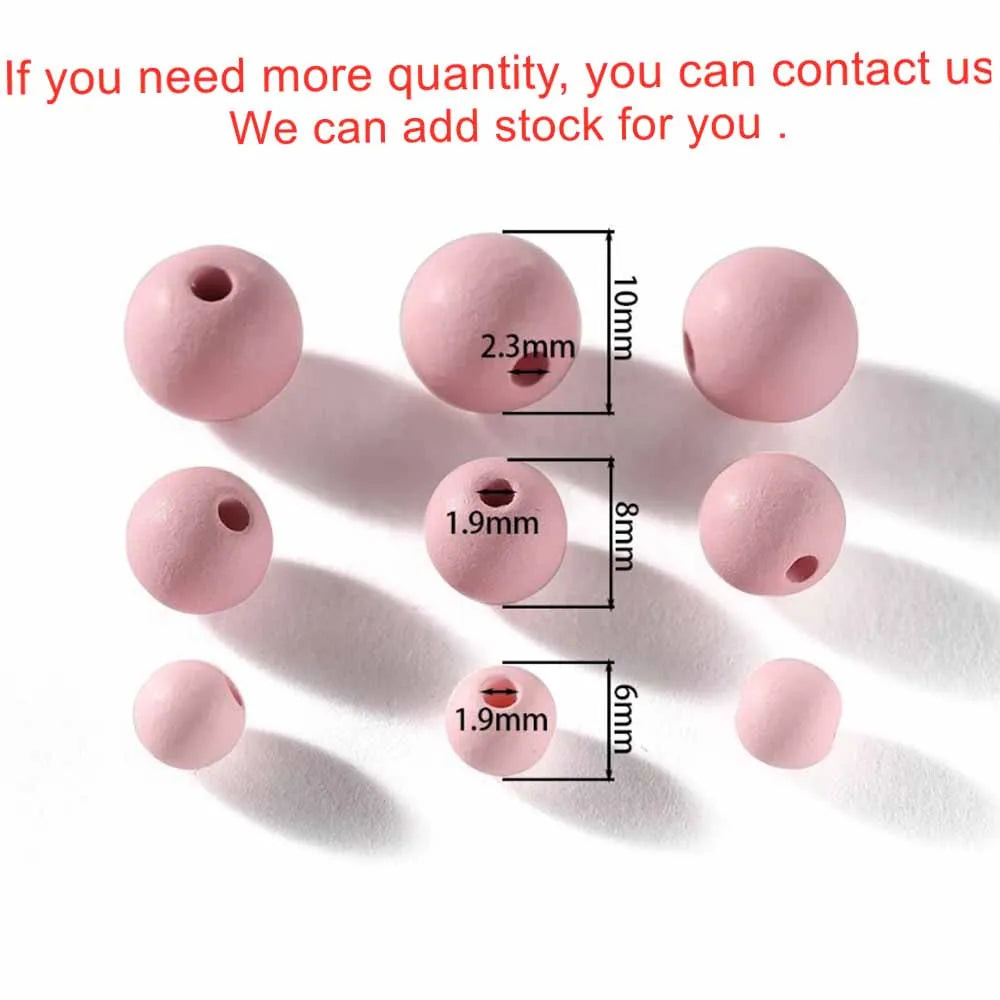 A collection of matte pink acrylic round beads of various sizes and diameters.