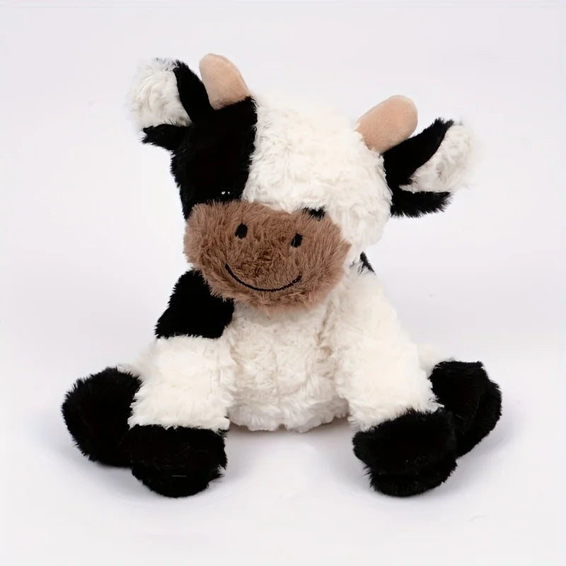 A white and black plush cow toy with brown accents, featuring soft, fluffy texture.