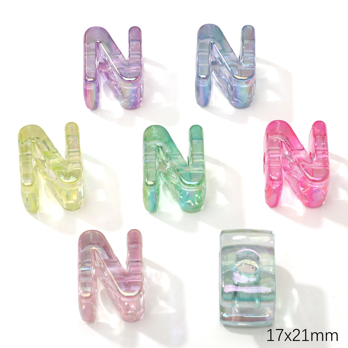 A set of colorful, iridescent acrylic letter N alphabet beads in various shades of purple, green, and pink.