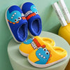 A pair of blue and yellow cartoon dinosaur plush slippers resting on a light green surface.