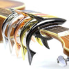 A close-up of a metal shark guitar capo with various colored plastic and metal teeth.
