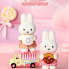 A white bunny plush toy standing on a yellow and pink train, part of the Miffy Bakery Series.