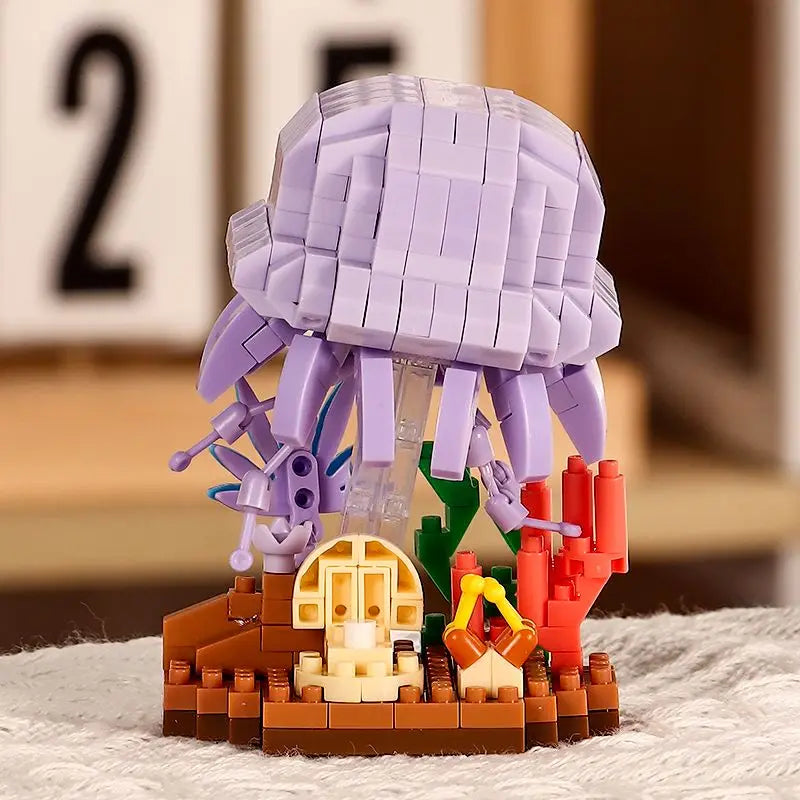 A purple and gray LEGO-style building block model of a shark, crab, and clownfish set on a brown base.