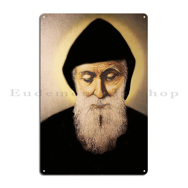 A vintage metal wall sign featuring a portrait of Saint Charbel with a halo effect.