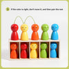 A set of nine colorful, smooth, egg-shaped wooden toys arranged in a grid for color matching practice.