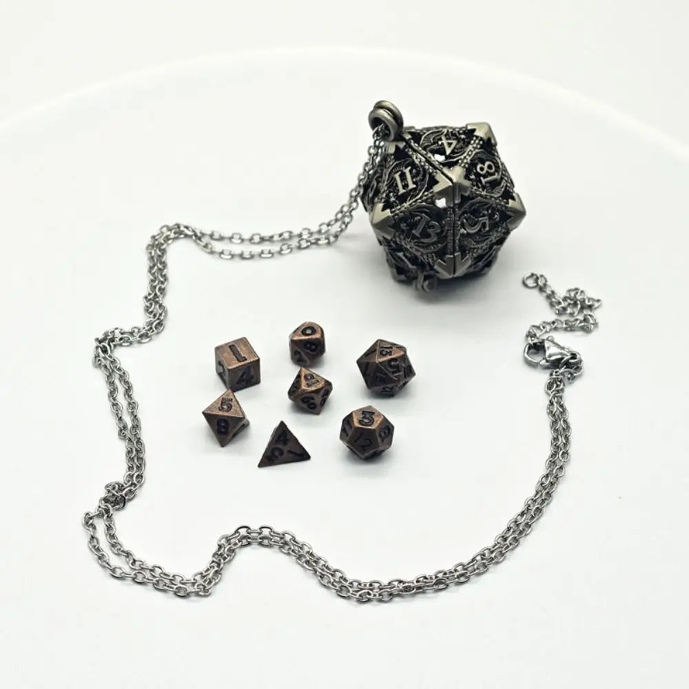 A metal polyhedral dice set with a pendant storage case resting on a white background.