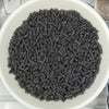 A bowl filled with dark gray polymer clay slice sprinkles for slime and DIY crafts