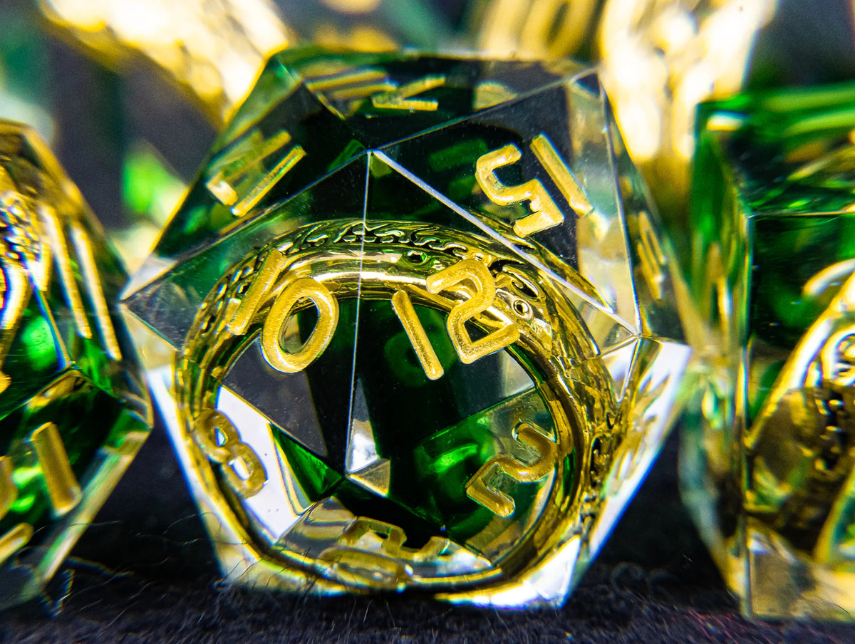 A close-up of a set of resin dice with golden elven numbers, featuring green and yellow tones.