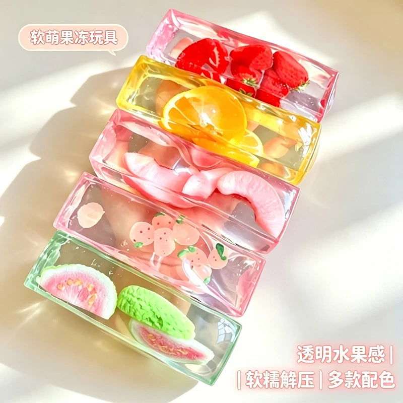 A set of pink and clear plastic fruit ice cube squishy stress relief toys featuring various fruits like strawberries, oranges