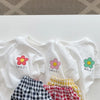 A set of white girls' summer t-shirts and shorts with floral print details