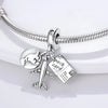Sterling silver charm beads featuring a globe, an airplane, and a postcard attached to a bracelet chain.