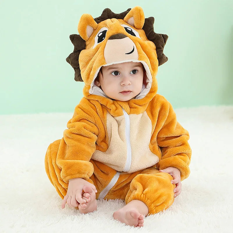 A baby wearing an adorable orange and tan animal hooded romper with ears, sitting on a white surface.