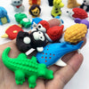 A hand holds several colorful 3D puzzle animal erasers, including a red bird, yellow hedgehog, and green dinosaur.
