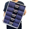 A box containing five skeins of purple alpaca wool yarn for knitting and crochet.