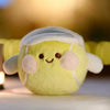 A soft yellow plush ball with white accents, resembling a sports ball charm.