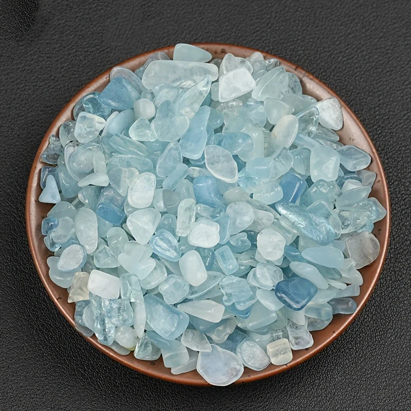 A pile of light blue to cyan aquamarine chips in a terracotta bowl.