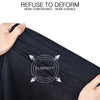 A hand is pulling a black t-shirt to demonstrate its elasticity and durability.