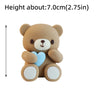 A light brown 3D bear cake topper with a blue heart detail.