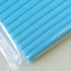 A close-up view of a light blue polymer clay block wrapped in clear plastic film.