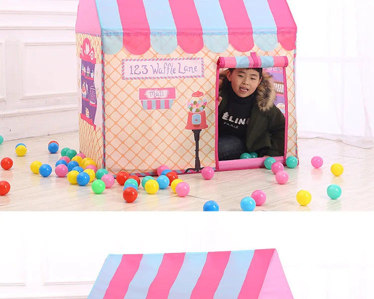 A pink and blue striped play tent decorated like a waffle lane with colorful balls on the floor.