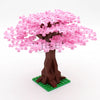 A model of a pink sakura cherry blossom tree built from interlocking plastic blocks, set on a green base.