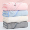 A stack of four bath towels in pink, light blue, white, and gray colors.