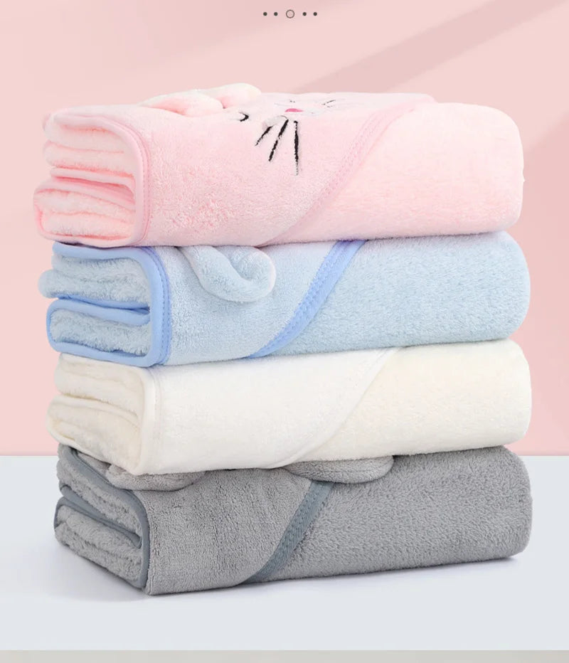 A stack of four bath towels in pink, light blue, white, and gray colors.