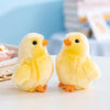 A pair of adorable yellow chick plush toys with orange beaks and feet resting on a white surface.