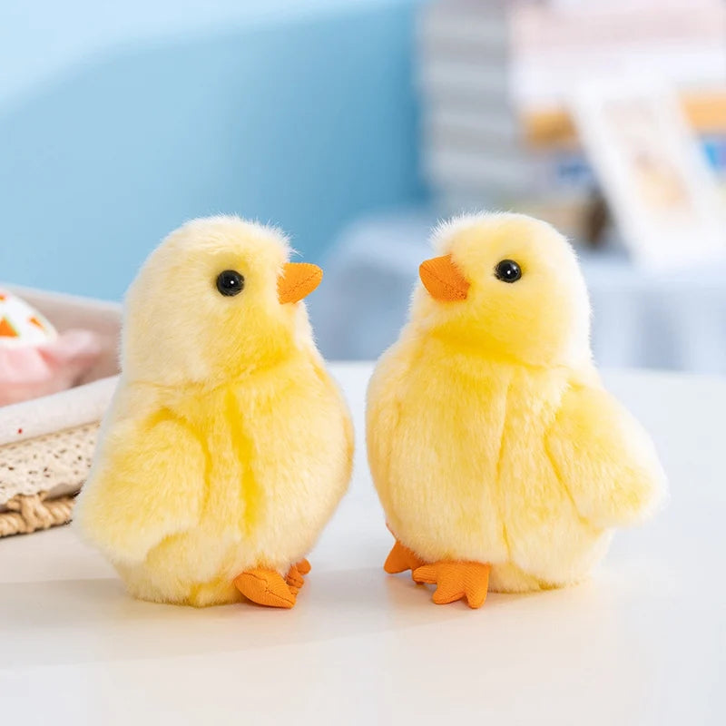 A pair of adorable yellow chick plush toys with orange beaks and feet resting on a white surface.