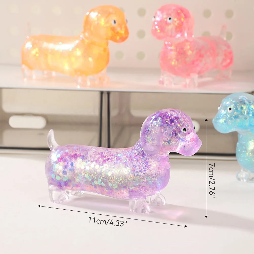 A purple glitter dachshund squishy toy next to pink and yellow versions.