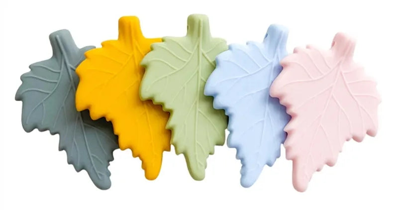 A row of five silicone chew necklaces in pastel colors, including yellow, light green, blue, and pink.