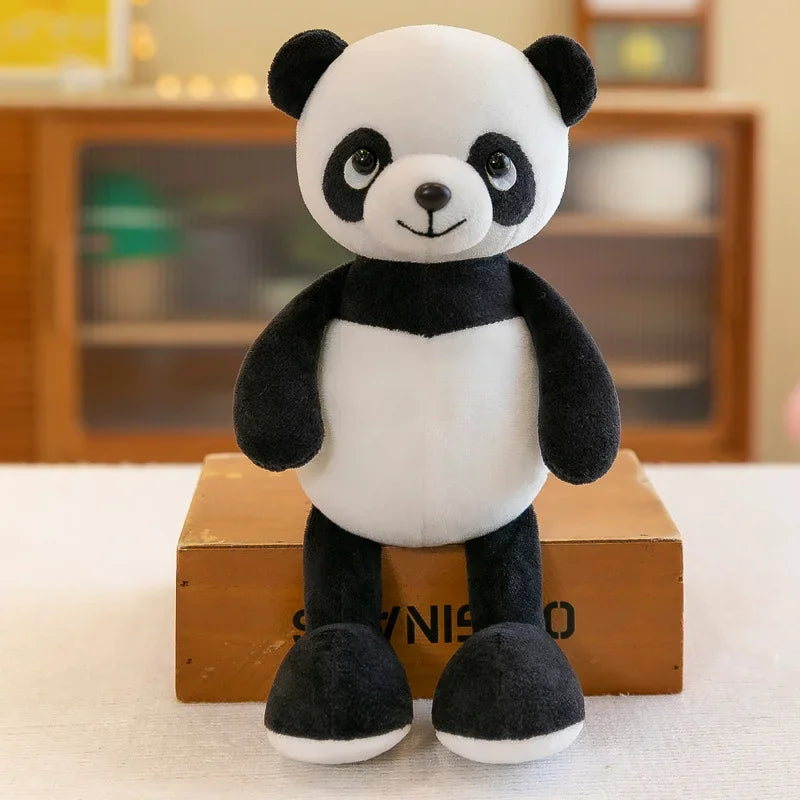 A cute panda plush toy with black and white fur sitting on a wooden box.