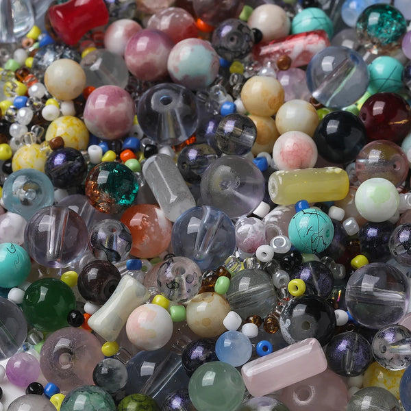 Gros plan sur une variété de perles de séparation en verre colorées, incluant rose, violet, vert et transparent.