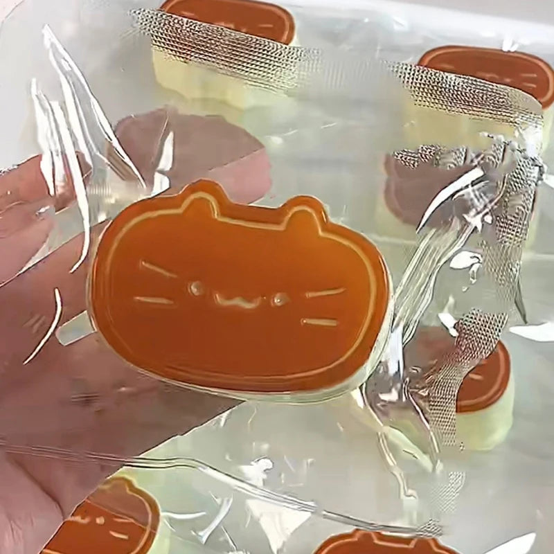 A hand holds an orange cat shaped squishy stress-relief toy in clear packaging.