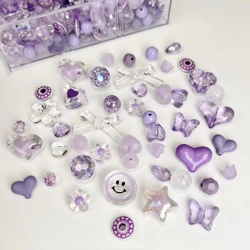 A collection of mixed purple and clear acrylic bow and flower beads for jewelry making.