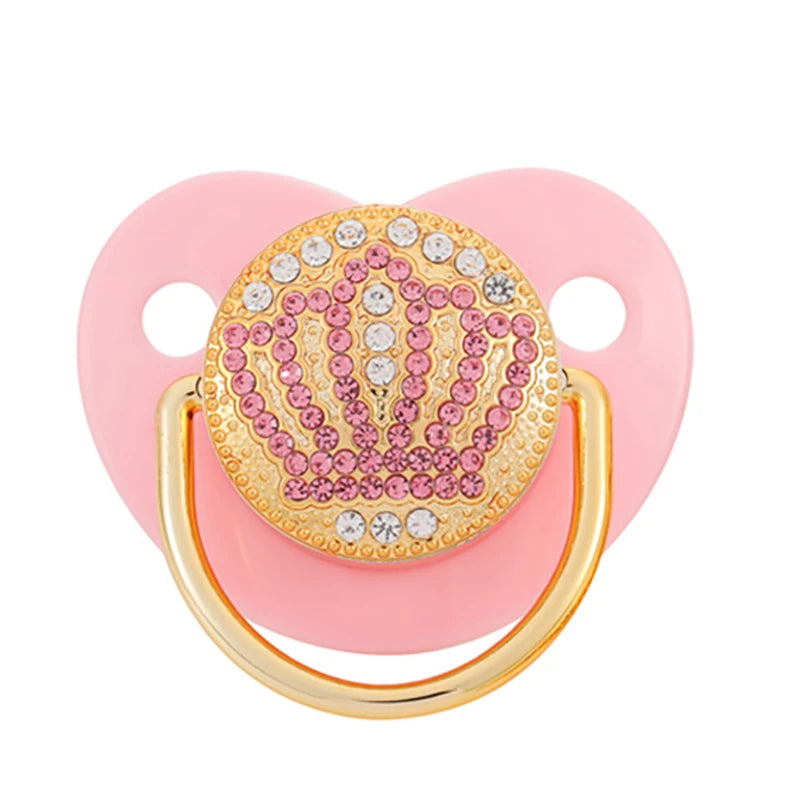 A pink pacifier featuring rose gold crystal bling and a gold ring for newborns.