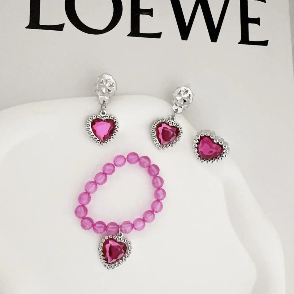A set of five pink and silver princess jewelry accessories including earrings and a necklace displayed on a white background.