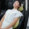 A woman wearing a white shirt is sitting in a black leather seat with a green plush animal lumbar support pillow.