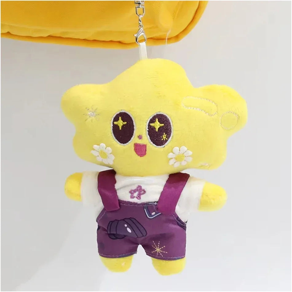 A yellow plush pendant doll of a character wearing purple overalls and a white shirt.