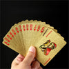 A hand holds a deck of golden waterproof playing cards with various face cards and numbers.