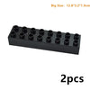 Bloc en plastique noir avec plusieurs trous, mesurant 12.8x3.2x1.9 cm.