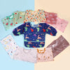 A collection of six colorful waterproof full sleeve baby bibs in various patterns and colors laid out on a light background.